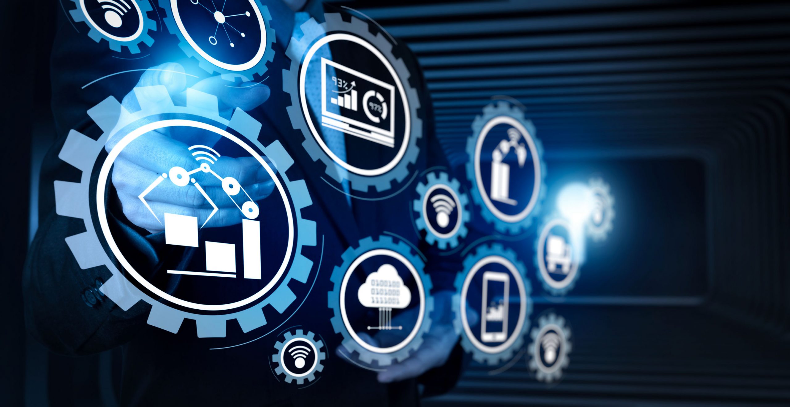 Smart factory and industry 4.0 and connected production robots exchanging data with internet of things (IoT) with cloud computing technology.Businessman hand pressing an imaginary button on virtual screen